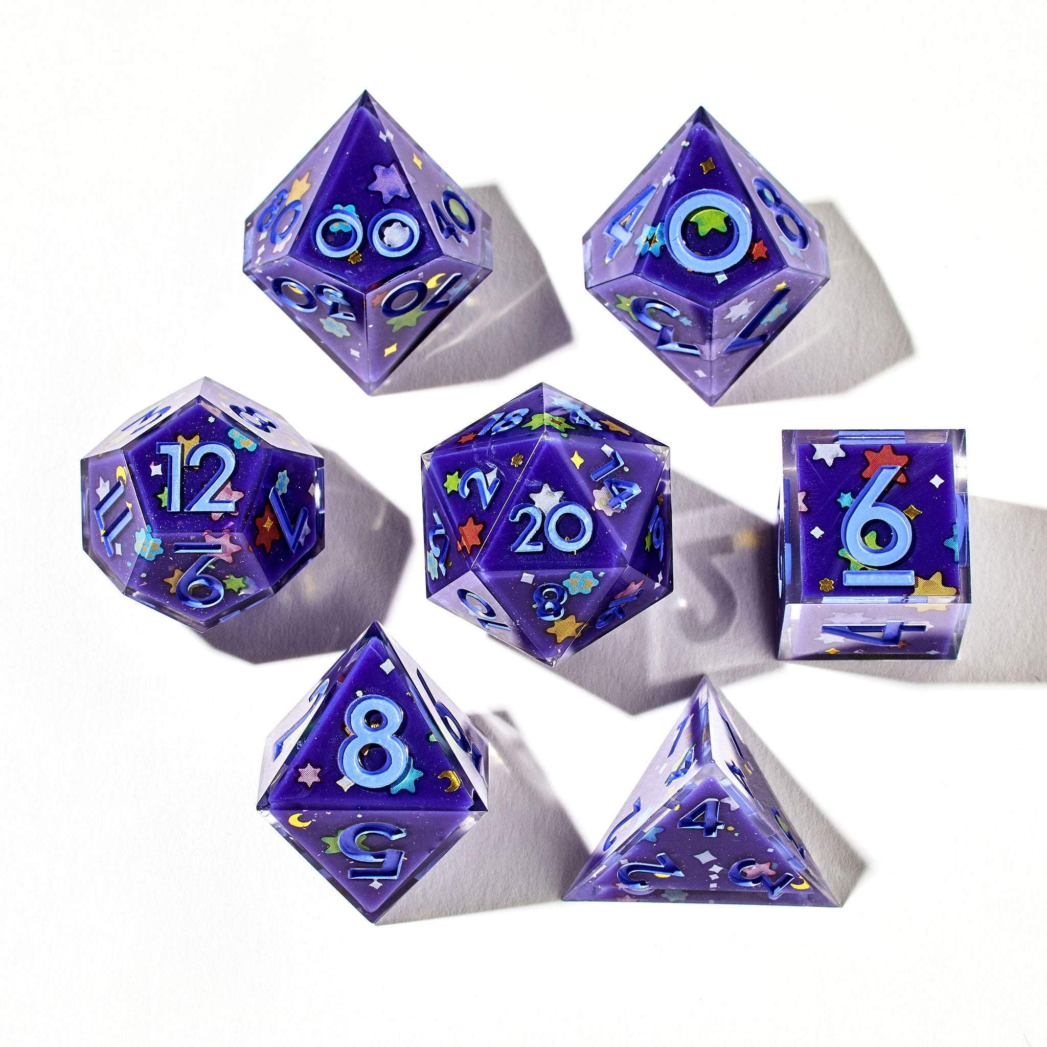 Close up of a purple dice set with light blue inked numbers and KonpeitÅ stickers on each face