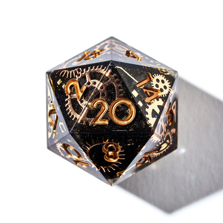 Close up of a black D20 with copper cogwheel designs and copper inked numbers