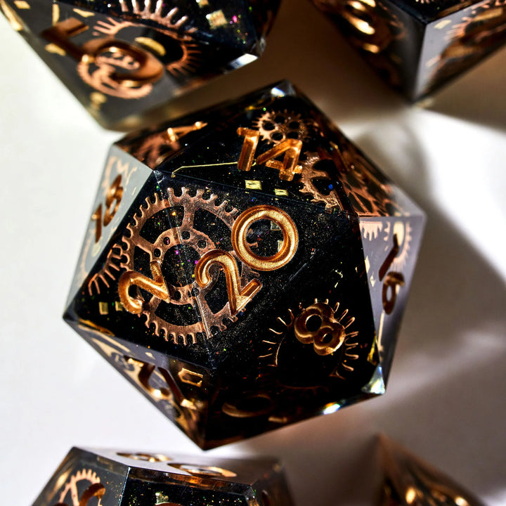 Well composed close up of a black D20 with copper cogwheel designs and copper inked numbers