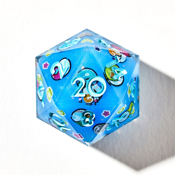 Close up of a light blue D20 die with light blue numbers and gachapon capsules