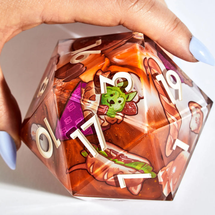 A Hand Holding a 95mm DnD D20 with Dog-Themed Pastry Designs on a White Background