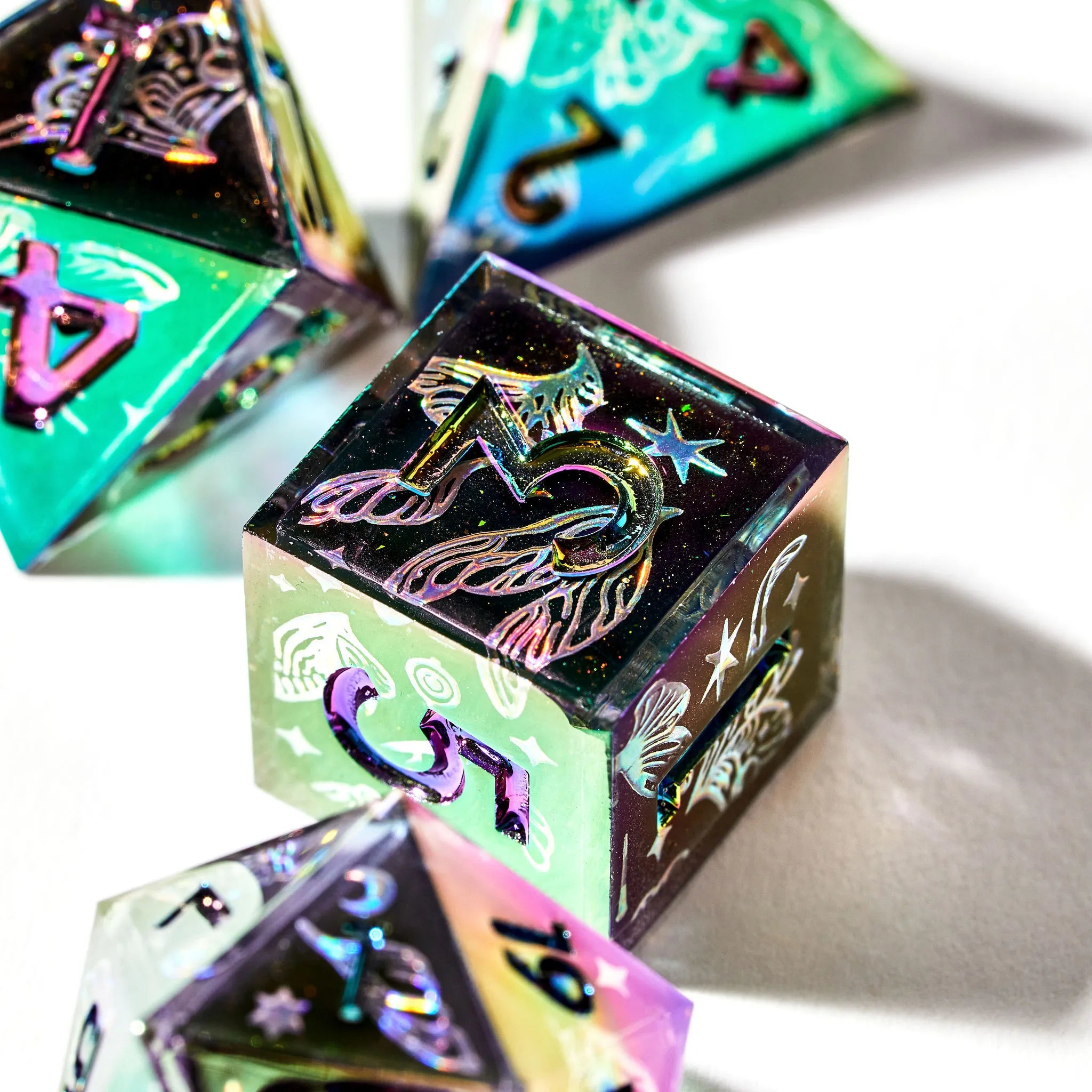 Well composed picture of a shiny d6 and other pieces with a black base and insect wing inspired designs