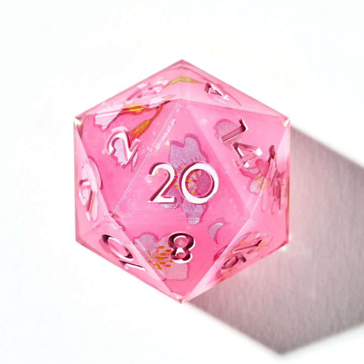 Close up of a pink D20 die with sakura flower designs on each face