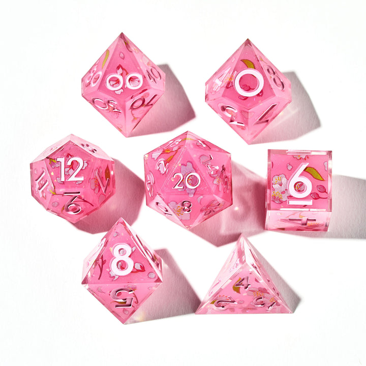 Close up of a pink dice set with sakura flower designs on each face