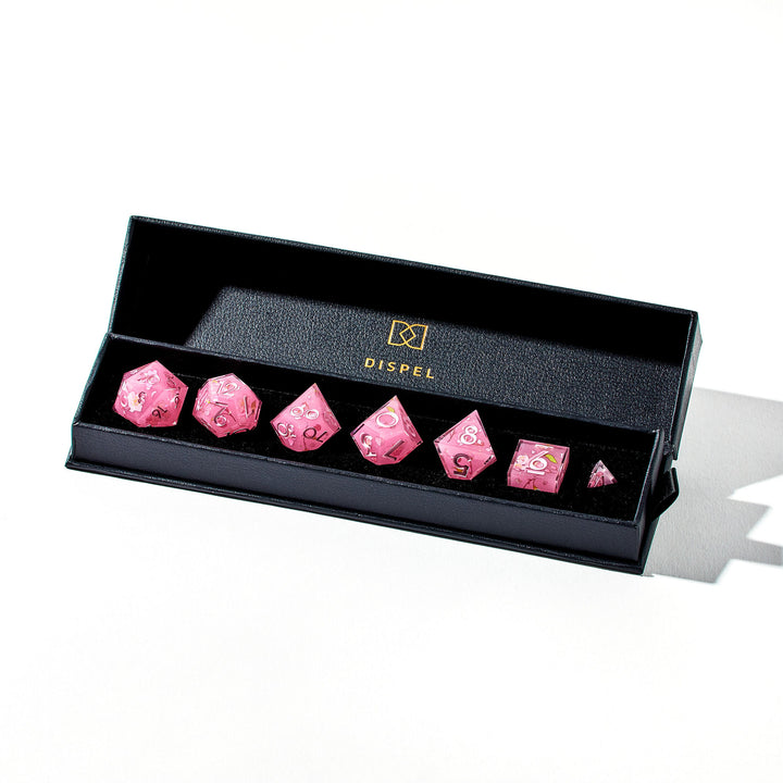 Close up of a pink dice set with sakura flower designs on each face in the packaging