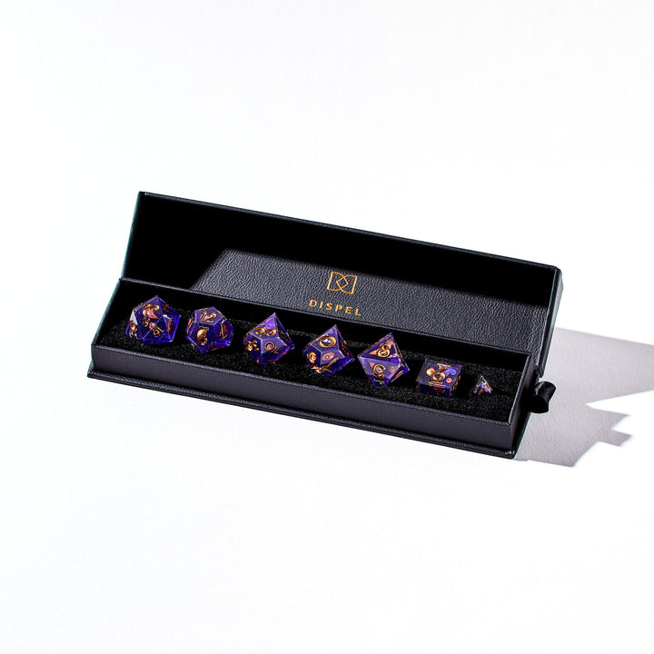 Close up of a purple dice set with mimic like designs in the packaging