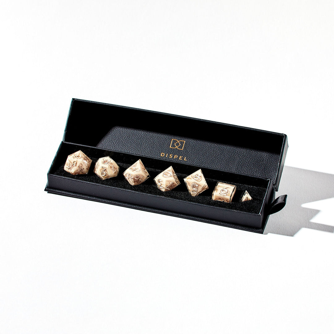 Close up of a beige dice set with sketch-like designs in the packaging