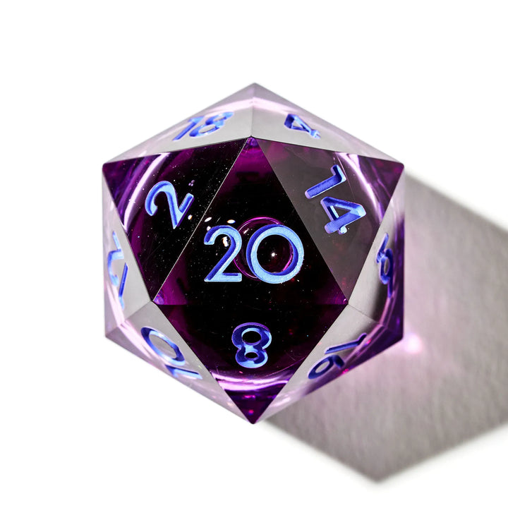 Close up of a purple D20 with a liquid core and light blue inked numbers