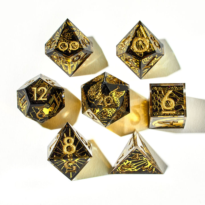 Close up of a black and gold dice set with wing and sun designs